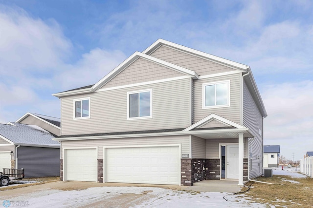 view of front of home with central air condition unit and a garage