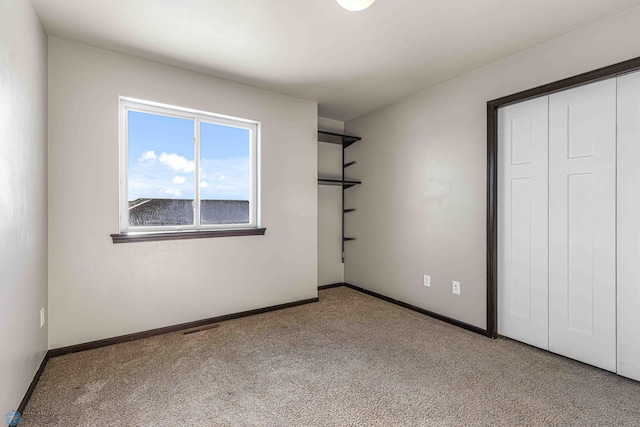 unfurnished bedroom featuring light carpet and a closet