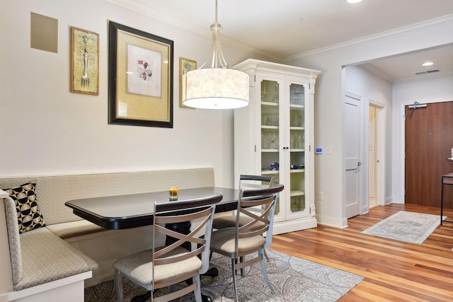 dining room with crown molding, breakfast area, and hardwood / wood-style flooring