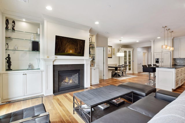 living room with light hardwood / wood-style floors and ornamental molding