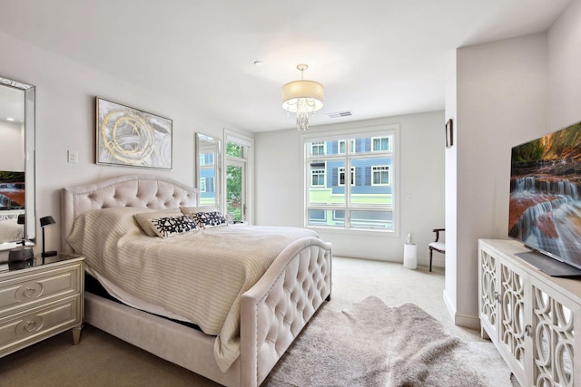 bedroom with light colored carpet and a chandelier