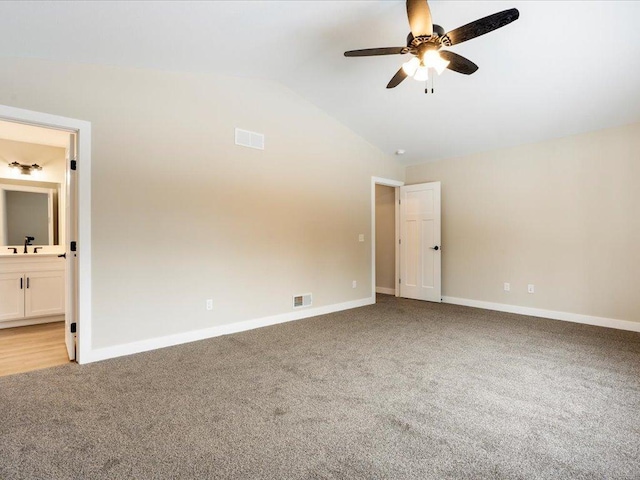 empty room with light carpet, sink, ceiling fan, and vaulted ceiling