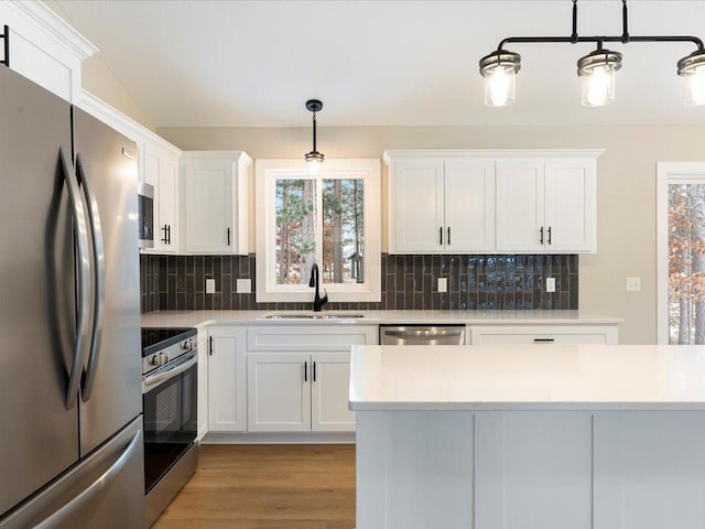 kitchen with appliances with stainless steel finishes, light countertops, and a sink