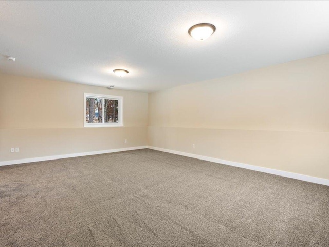 unfurnished room featuring carpet flooring, a textured ceiling, and baseboards