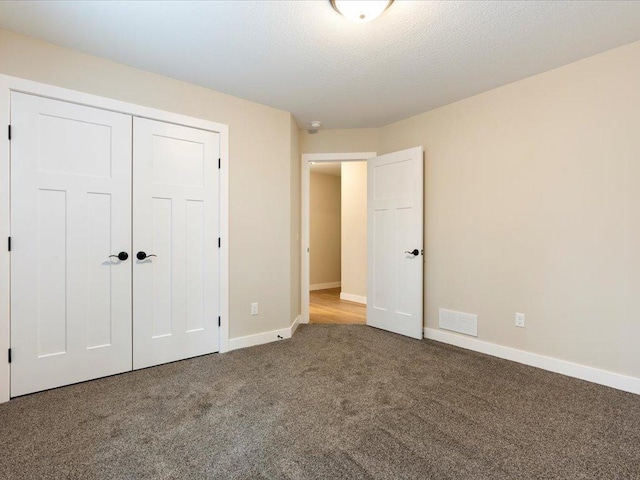 unfurnished bedroom featuring baseboards, a closet, visible vents, and carpet flooring