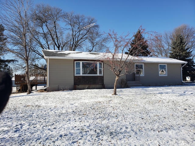 snow covered house with a deck