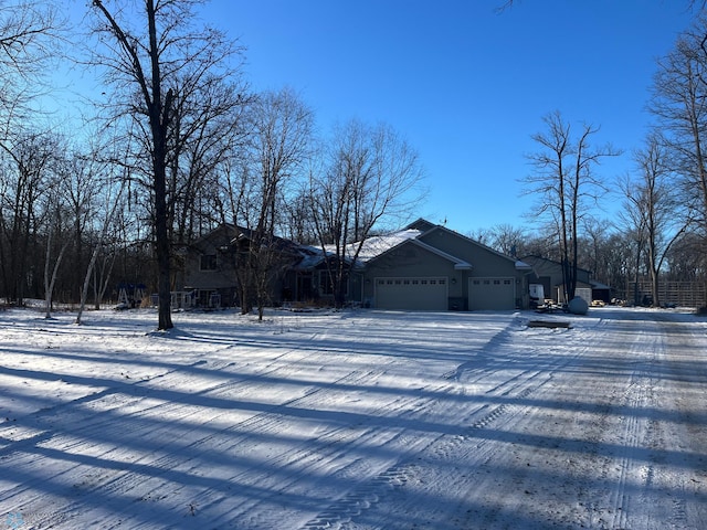 snow covered property with a garage