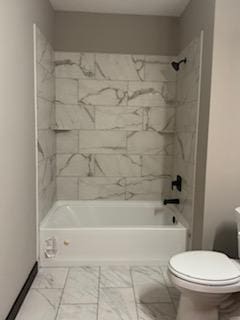 bathroom featuring toilet and tiled shower / bath