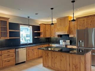 kitchen with a center island, sink, hanging light fixtures, decorative backsplash, and stainless steel appliances