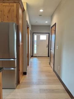 hall with light wood finished floors, baseboards, and recessed lighting