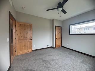 unfurnished bedroom featuring baseboards, ceiling fan, and carpet