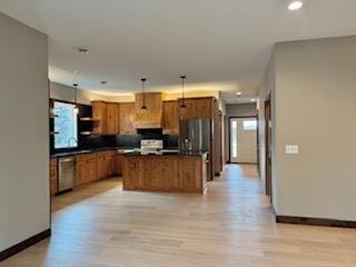 kitchen with dishwasher, a wealth of natural light, dark countertops, and brown cabinets