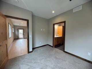 spare room featuring recessed lighting, carpet floors, baseboards, and visible vents