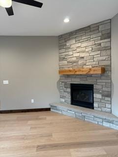 unfurnished living room with a ceiling fan, baseboards, a fireplace, and wood finished floors