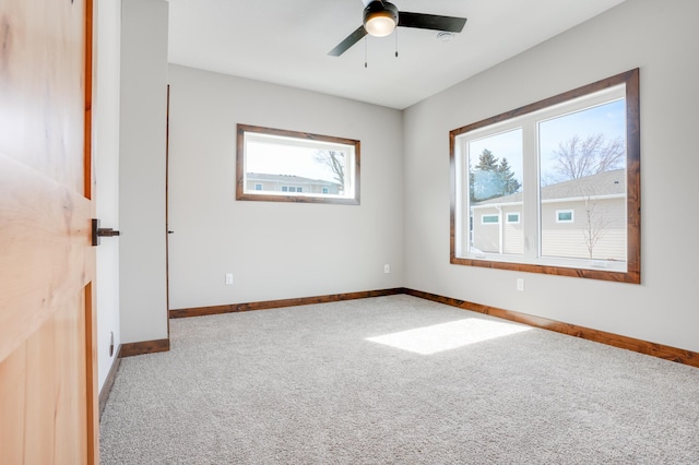 spare room featuring baseboards, ceiling fan, and carpet