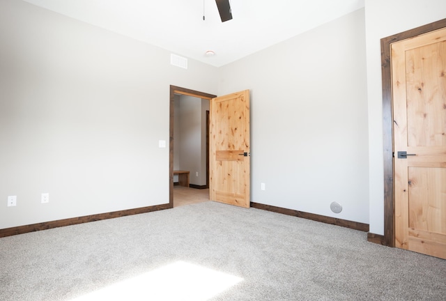 unfurnished bedroom with carpet flooring, baseboards, ceiling fan, and visible vents