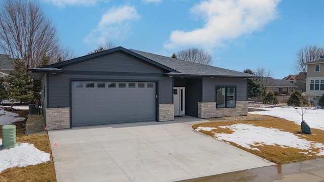view of front of property featuring stone siding, a garage, concrete driveway, and roof with shingles