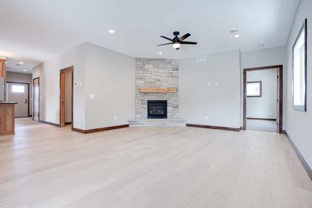 unfurnished living room with a wealth of natural light, visible vents, light wood-style flooring, and a ceiling fan