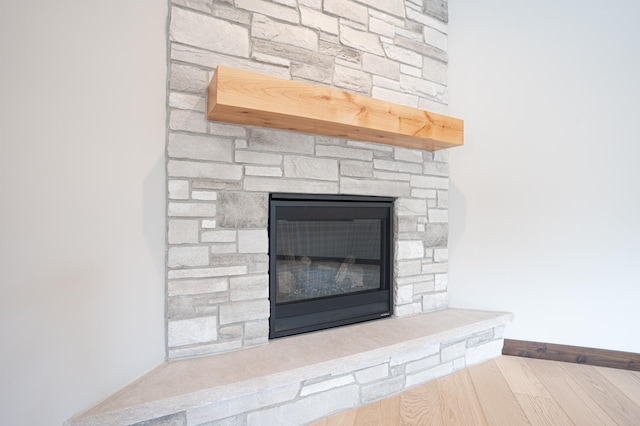 details with baseboards, a fireplace, and wood finished floors