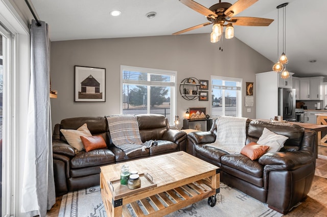 living room featuring ceiling fan, lofted ceiling, a healthy amount of sunlight, and light hardwood / wood-style floors