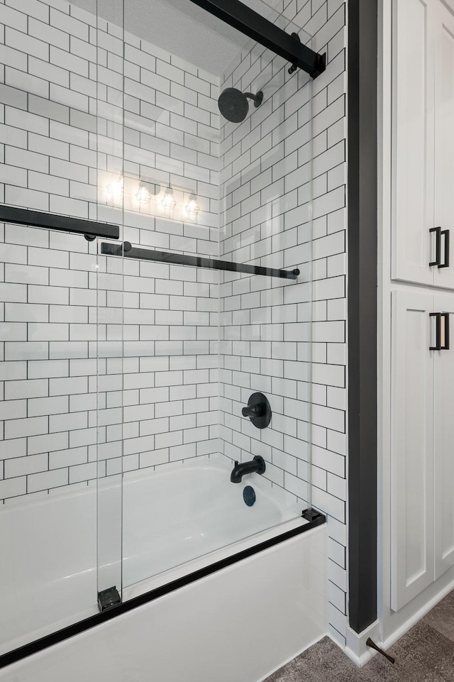 bathroom with combined bath / shower with glass door