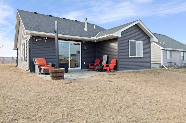 rear view of house with an outdoor fire pit, a yard, and a patio area