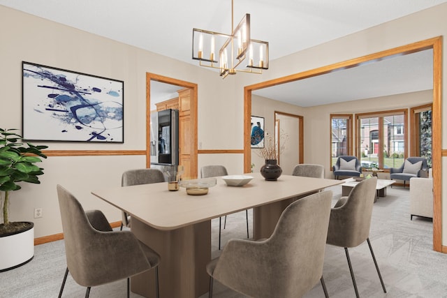 dining room featuring baseboards and an inviting chandelier