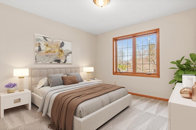 bedroom with light colored carpet and baseboards