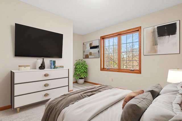 bedroom featuring baseboards and light carpet