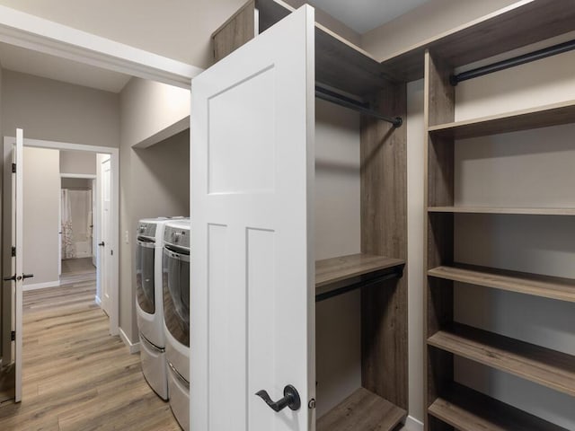 clothes washing area featuring washer and dryer and light hardwood / wood-style flooring