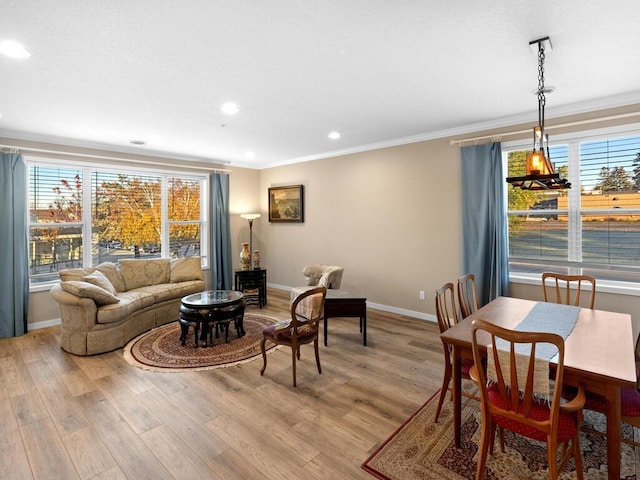 living room featuring crown molding, a wealth of natural light, and light hardwood / wood-style flooring