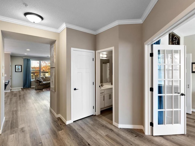 hall with hardwood / wood-style flooring, crown molding, and sink