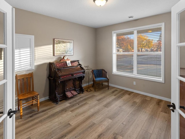 living area with french doors and light wood-type flooring