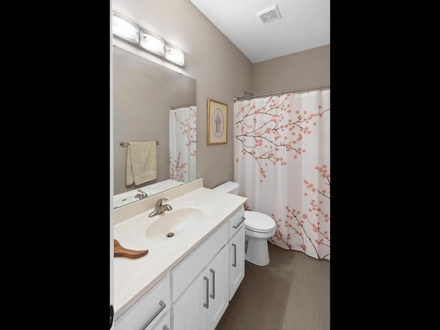 bathroom featuring vanity, curtained shower, and toilet