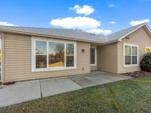 rear view of property featuring a patio and a lawn