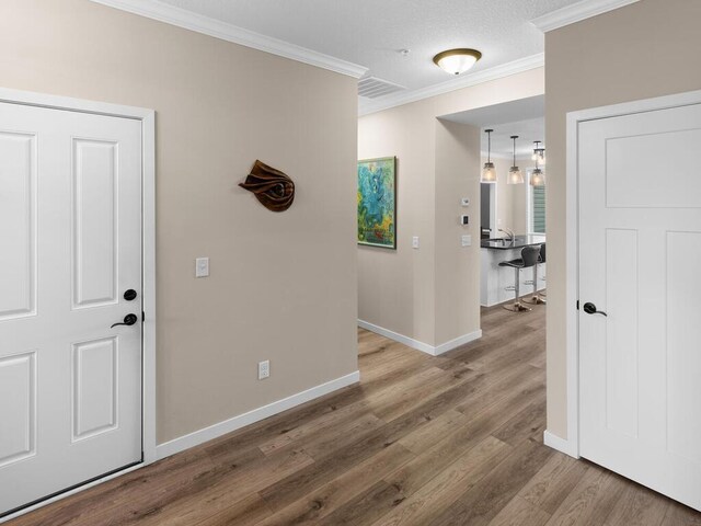 corridor with hardwood / wood-style flooring and ornamental molding