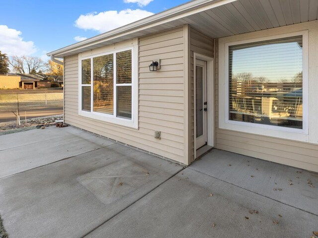 view of exterior entry with a patio area