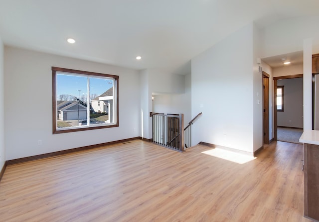 unfurnished living room with lofted ceiling and light hardwood / wood-style flooring