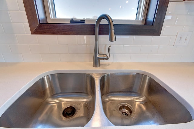 room details featuring dark brown cabinets, sink, and backsplash