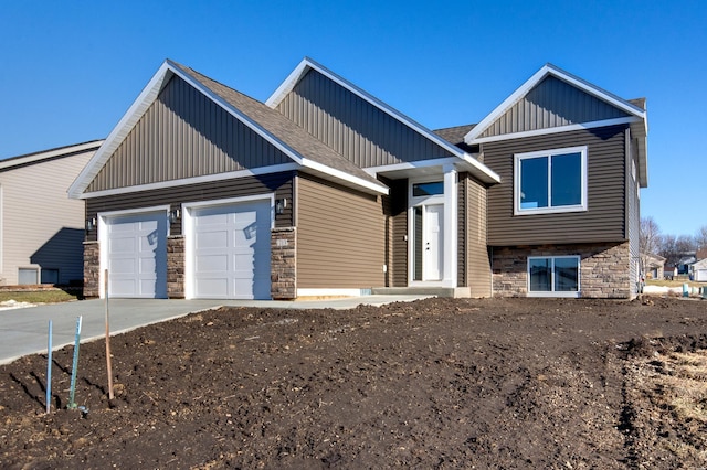 view of front of home featuring a garage, stone siding, driveway, and board and batten siding