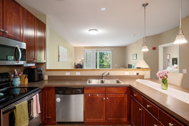 kitchen with kitchen peninsula, stainless steel appliances, hanging light fixtures, and sink