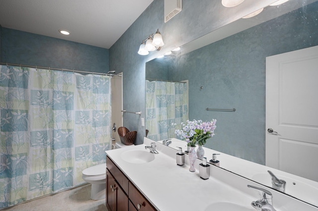 bathroom featuring tile patterned flooring, vanity, and toilet