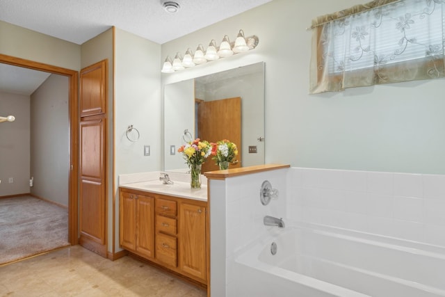 bathroom featuring a bathtub, vanity, and a textured ceiling