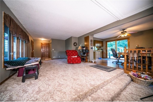 carpeted living room with ceiling fan