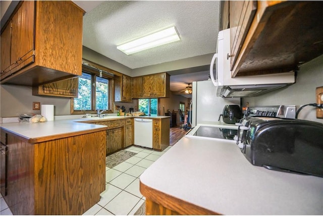 kitchen with ceiling fan, light tile patterned floors, white dishwasher, and a textured ceiling