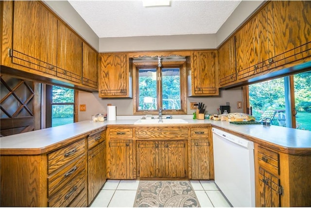 kitchen with kitchen peninsula, dishwasher, a textured ceiling, and sink