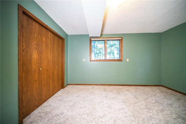 unfurnished bedroom with a closet, carpet floors, and a textured ceiling