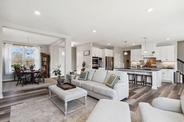 living room featuring hardwood / wood-style floors, sink, and a chandelier