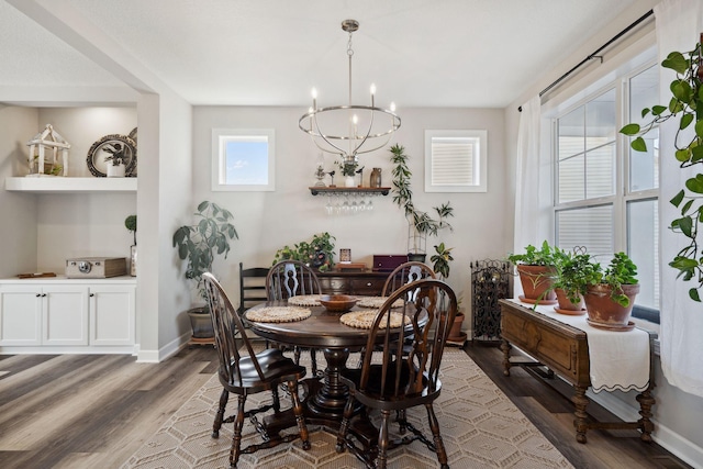 dining space with dark hardwood / wood-style flooring and an inviting chandelier