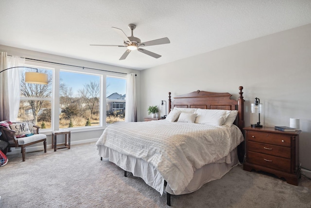 bedroom with ceiling fan, carpet, and a textured ceiling